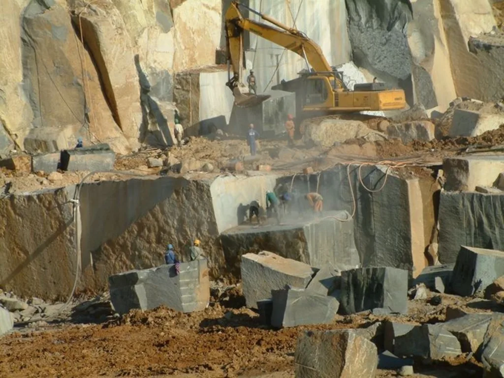 Natural stone quarry where cranes are extracting stones