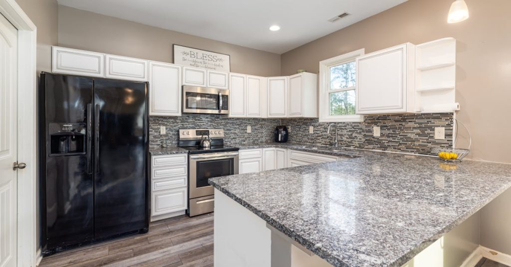 Elegant kitchen with sleek granite countertops and black appliances, perfect for modern living.