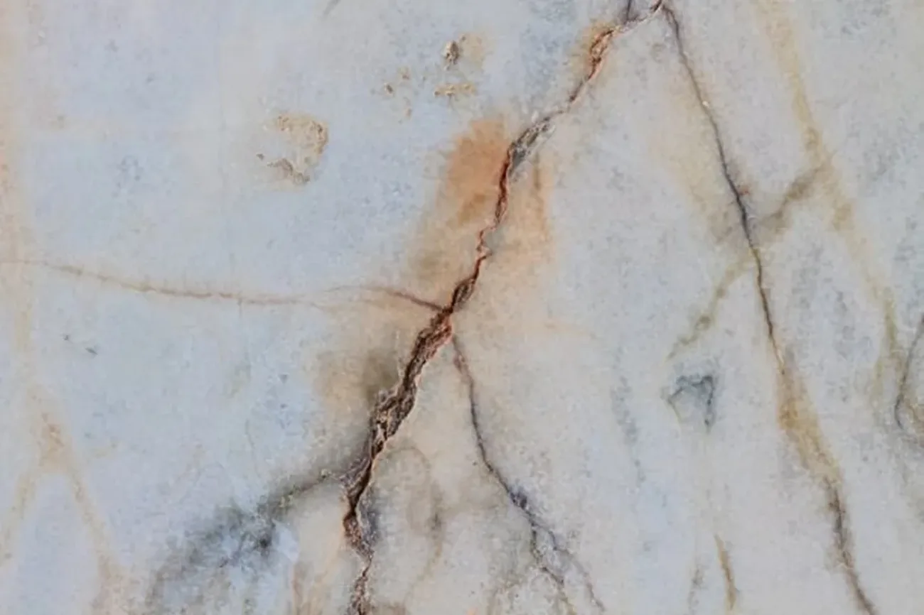 Light-colored granite with visible cracks.